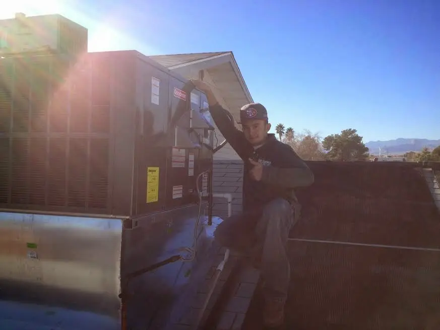 HVAC technician performing HVAC Inspection on a rooftop unit in Niagara